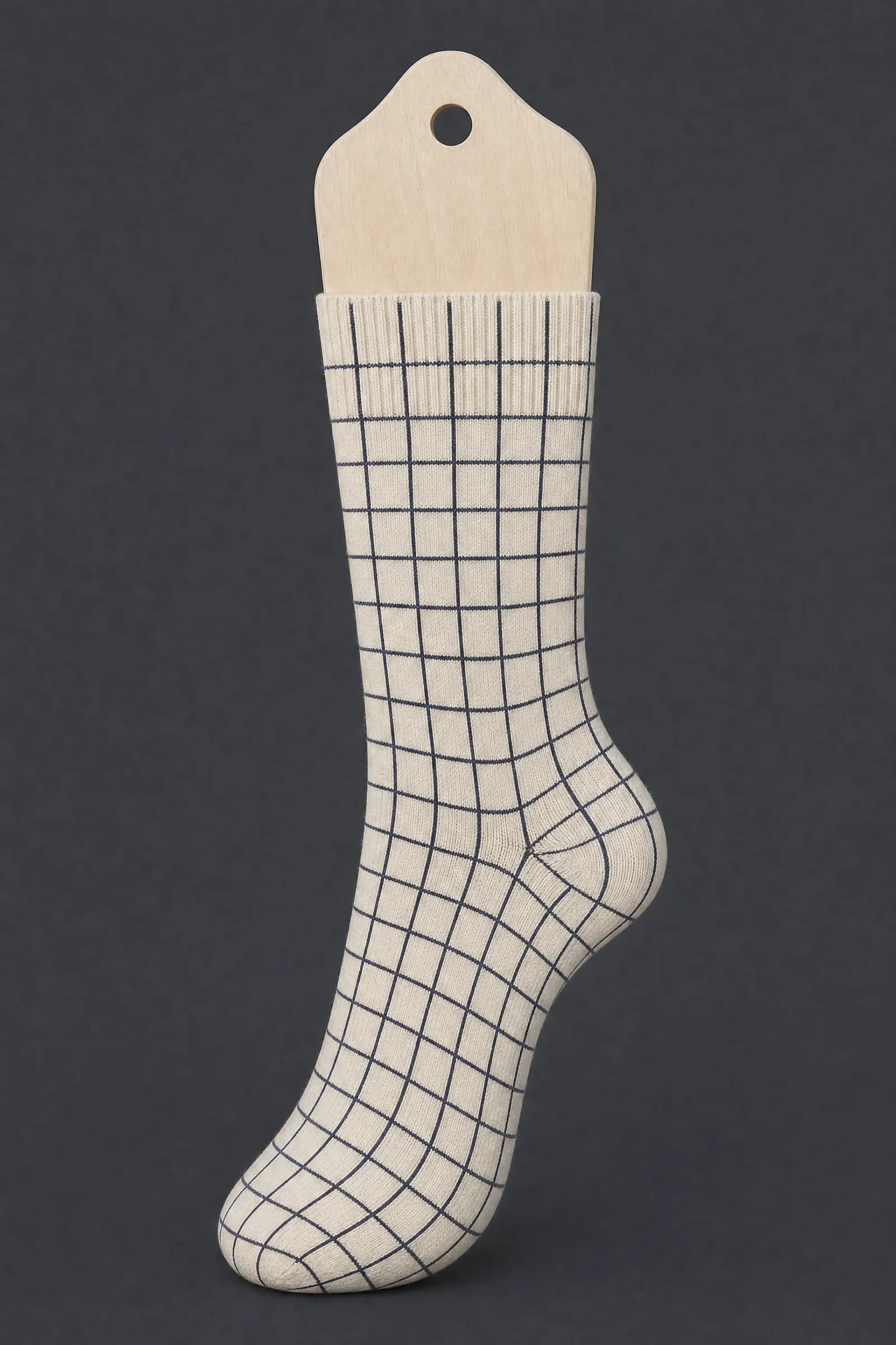 The Grid 12 pattern on a sock stretched over a sock form, showing how the drawing curves and compresses