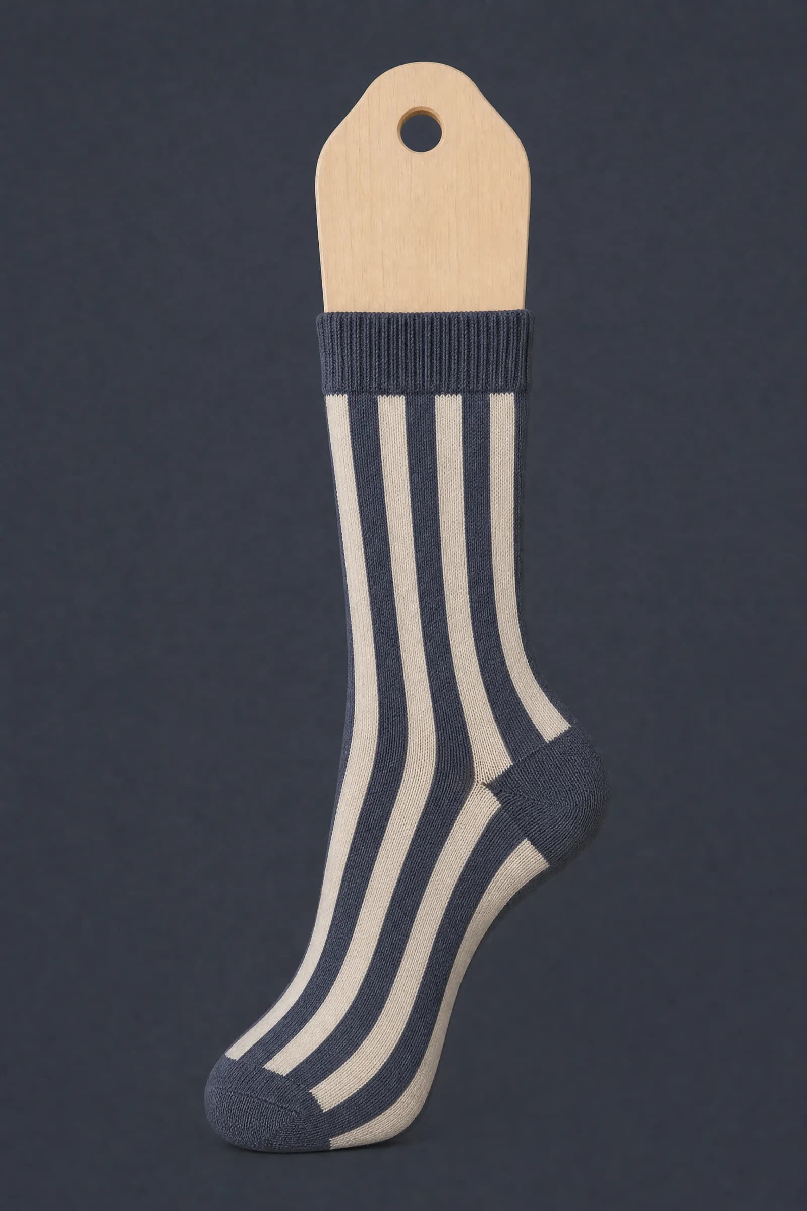 The Band Vertical pattern on a sock stretched over a sock form, showing how the drawing curves and compresses