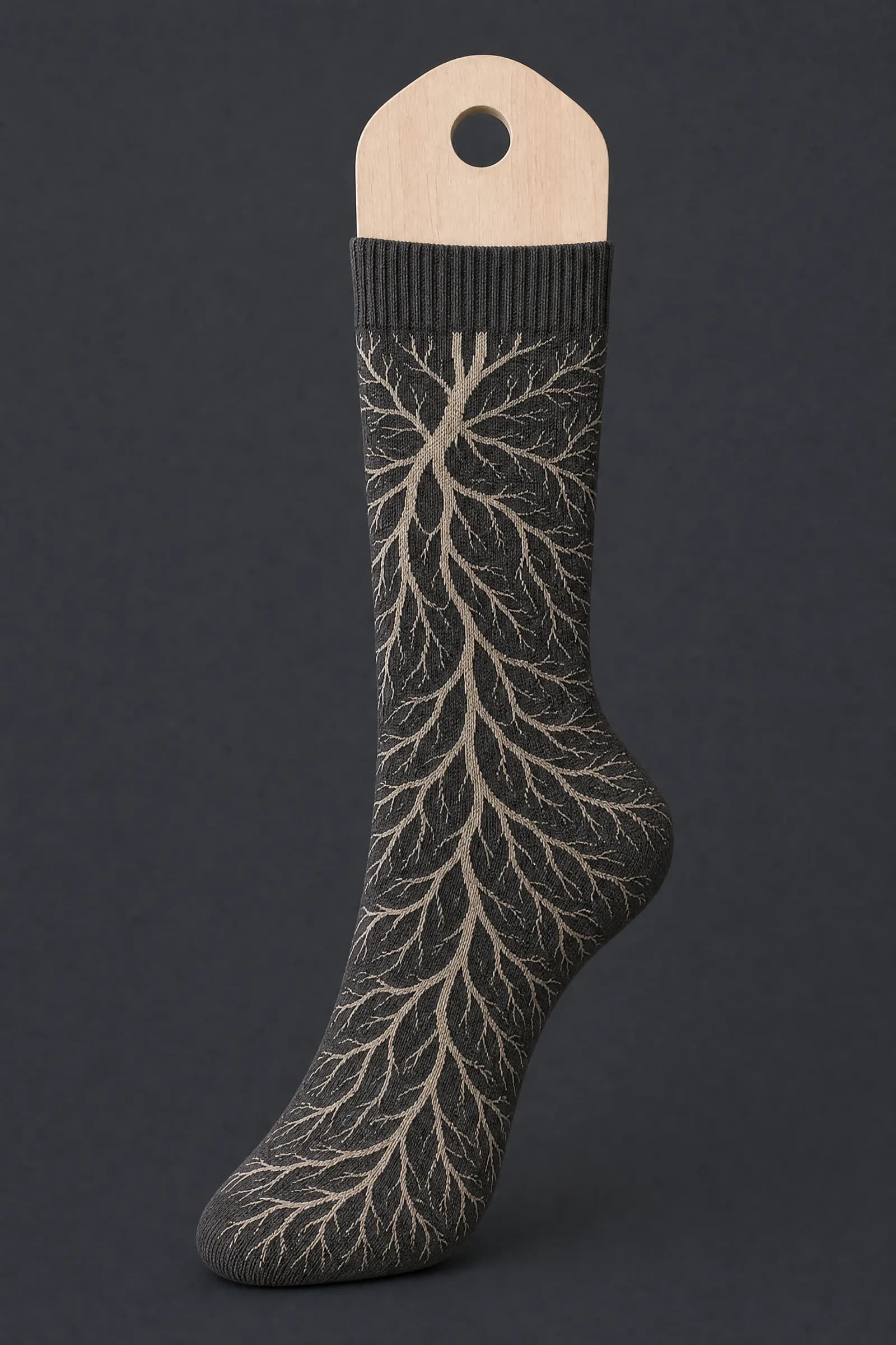 The Root System pattern on a sock stretched over a sock form, showing how the drawing curves and compresses