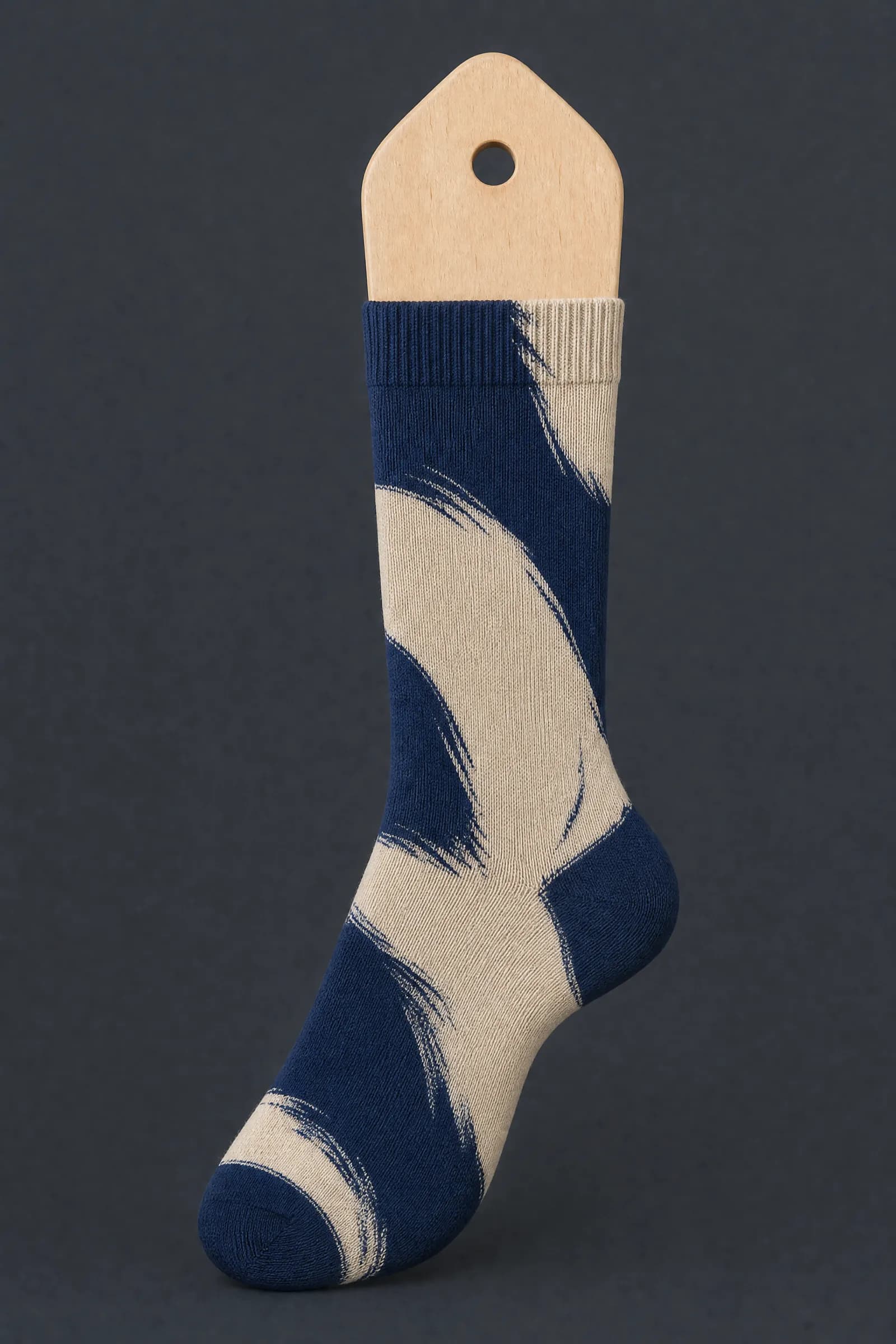 The Mark Large pattern on a sock stretched over a sock form, showing how the drawing curves and compresses