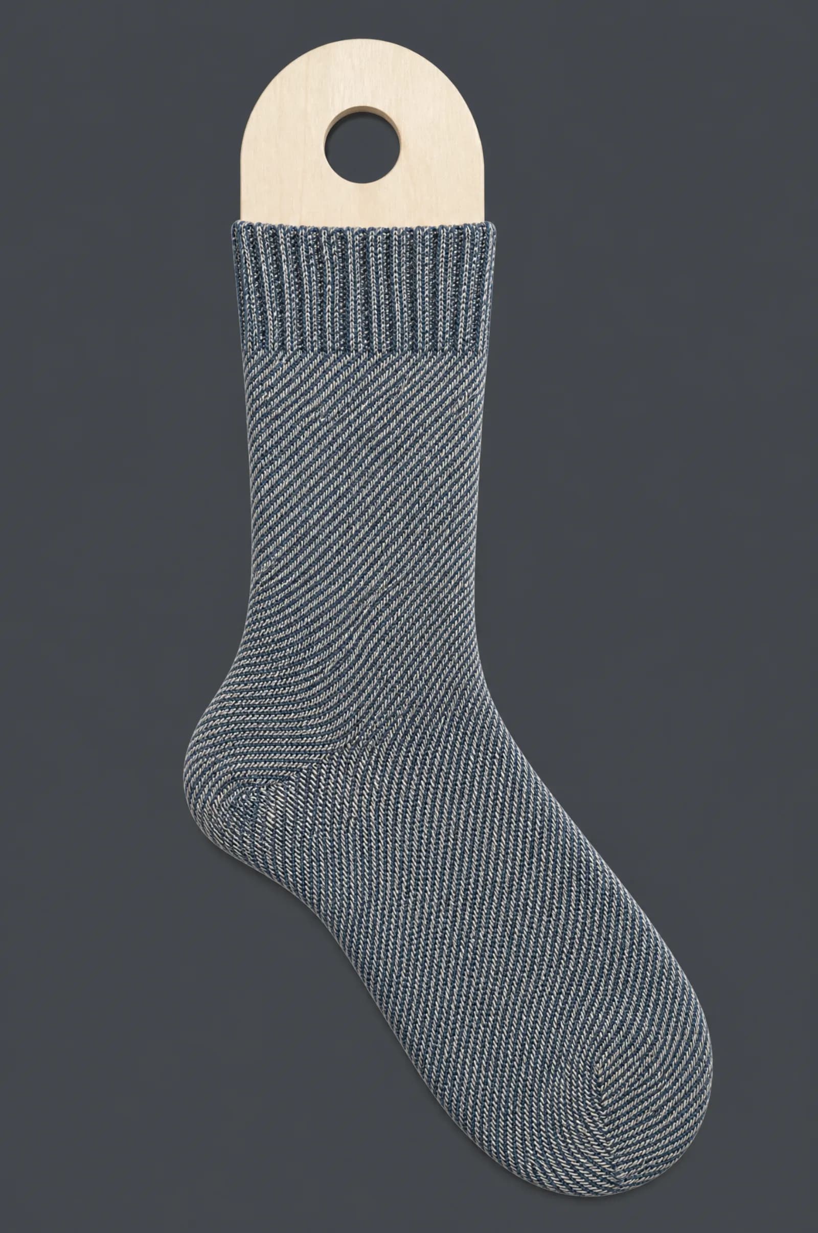 The Faux Denim pattern on a sock stretched over a sock form, showing how the drawing curves and compresses