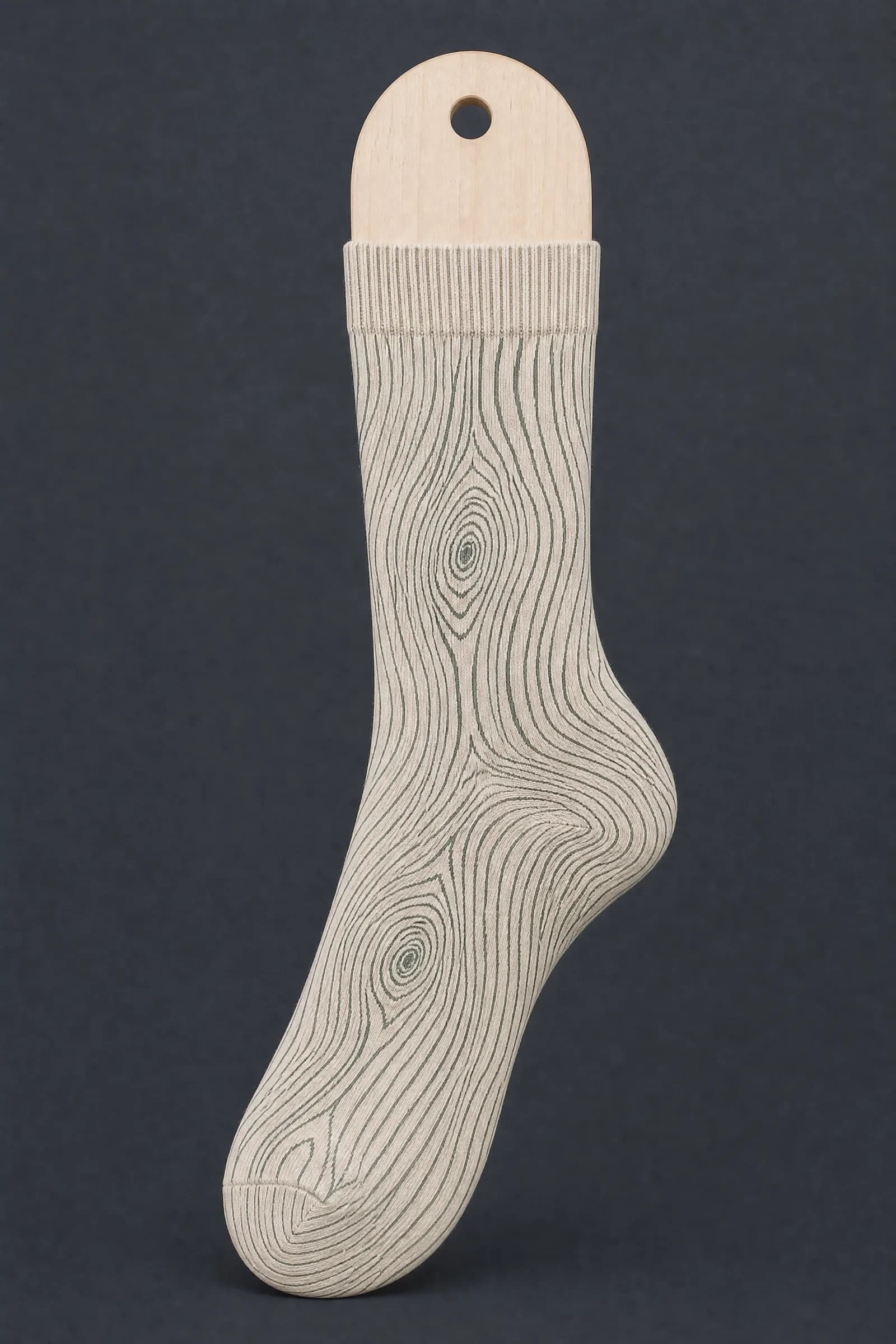 The Faux Grain pattern on a sock stretched over a sock form, showing how the drawing curves and compresses