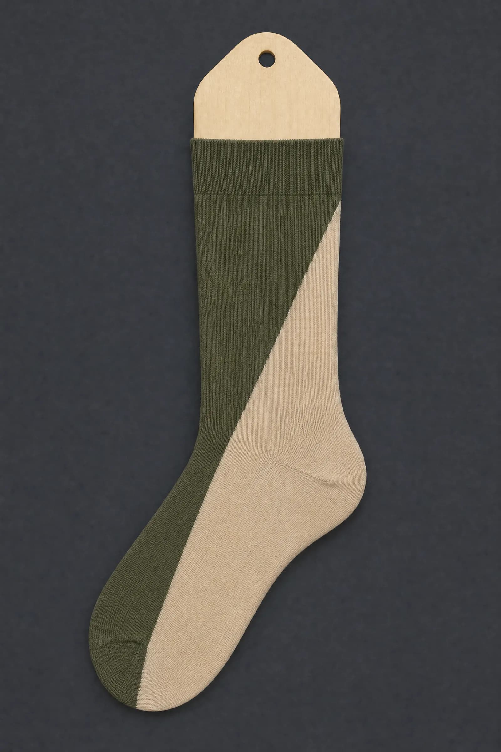 The Split Diagonal pattern on a sock stretched over a sock form, showing how the drawing curves and compresses