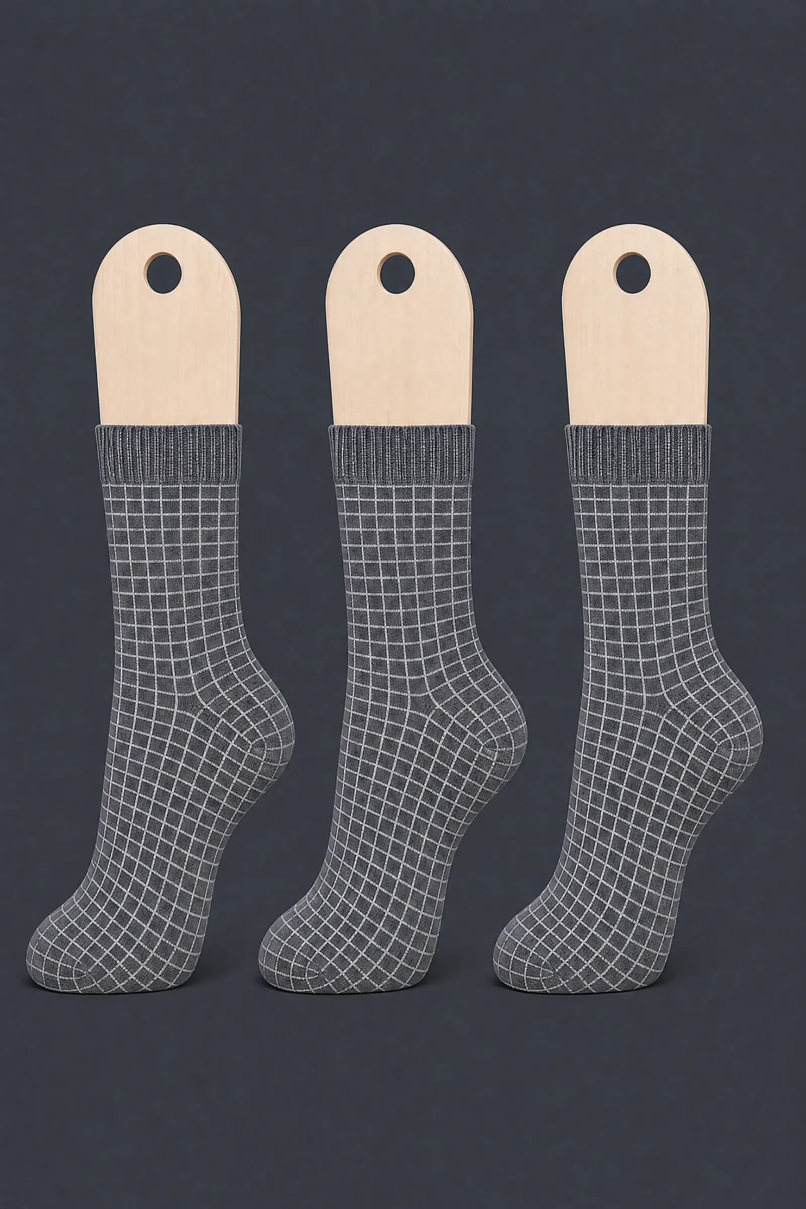 The Grid 3-Pack pattern on a sock stretched over a sock form, showing how the drawing curves and compresses
