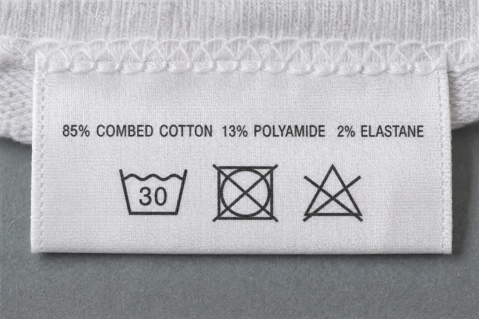 The sewn-in care label for Geometric Premium, showing the fibre composition and wash symbols
