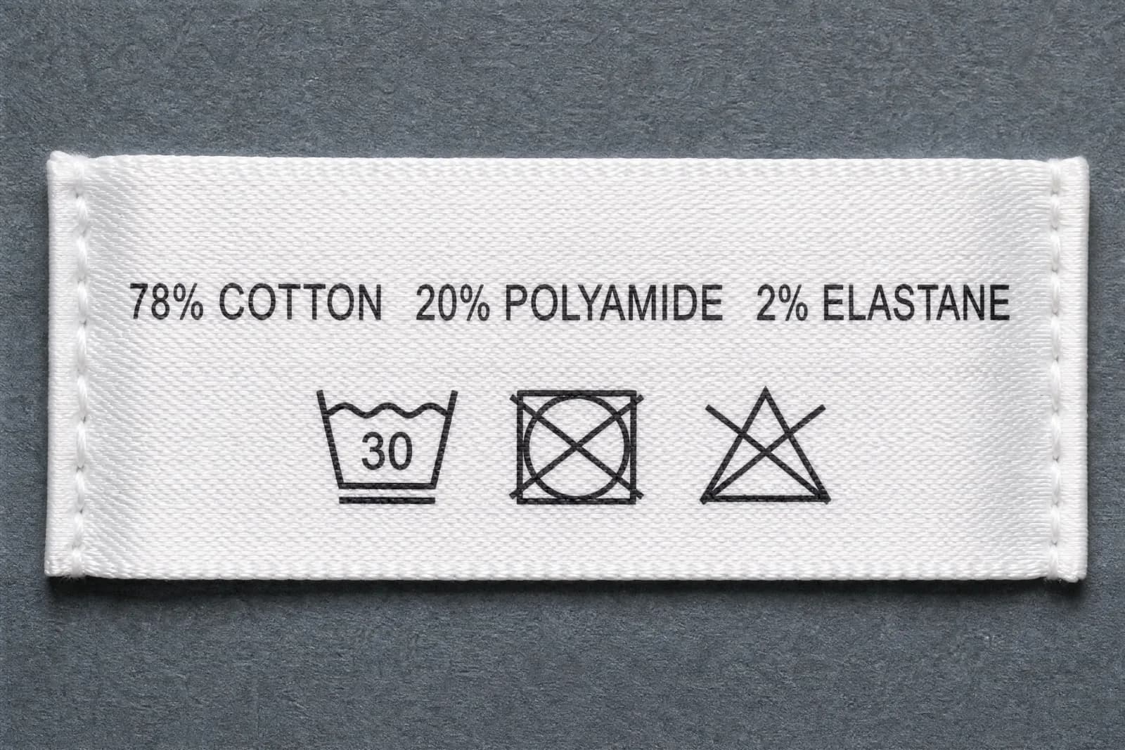 The sewn-in care label for Leaf Line, showing the fibre composition and wash symbols