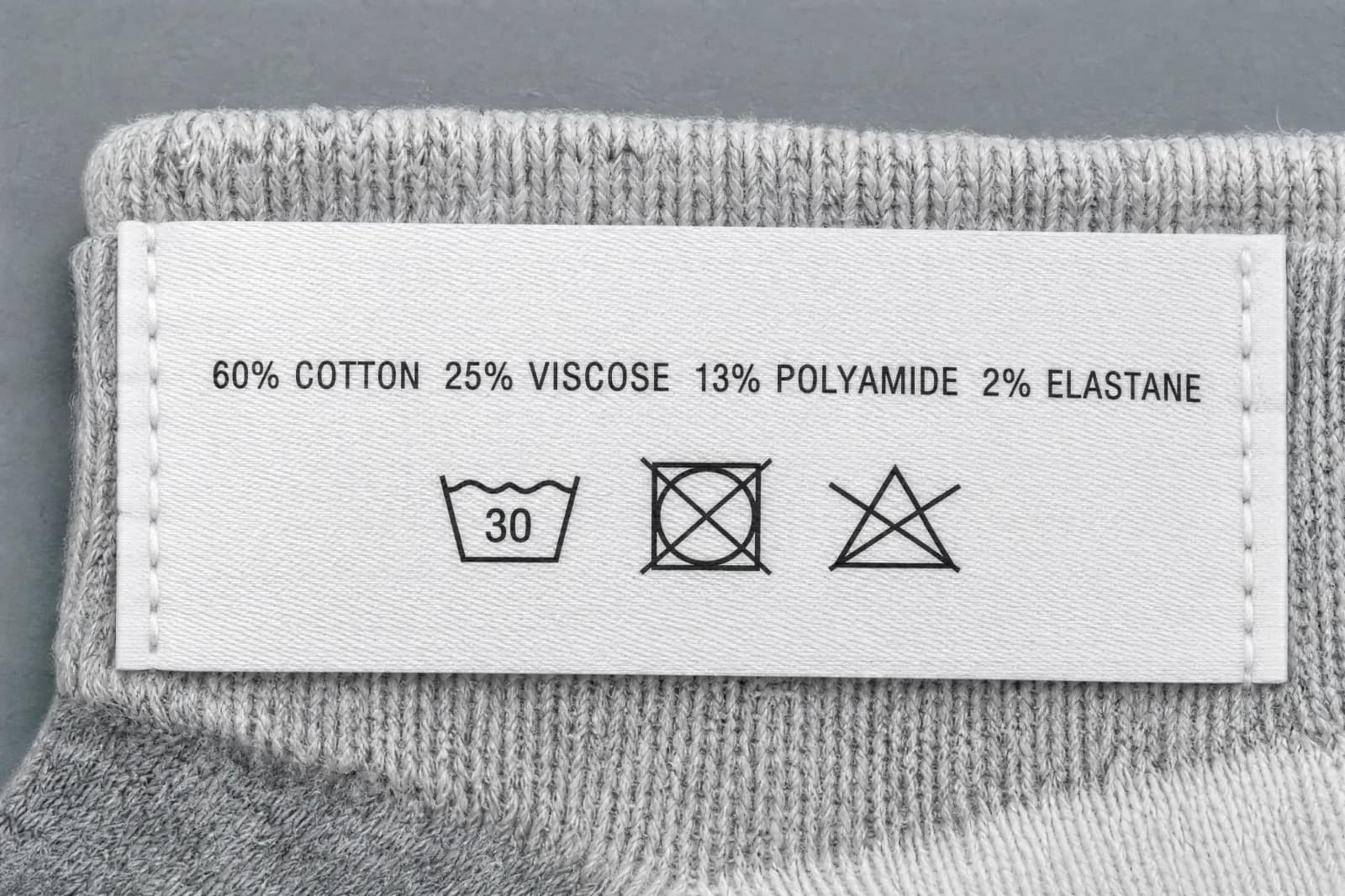 The sewn-in care label for Root System, showing the fibre composition and wash symbols